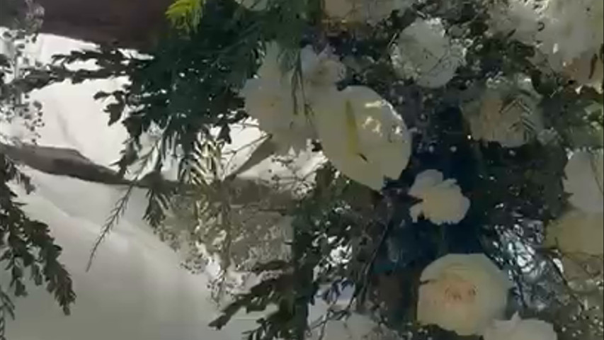 Pérgola rústica decorada con flores naturales para ceremonia