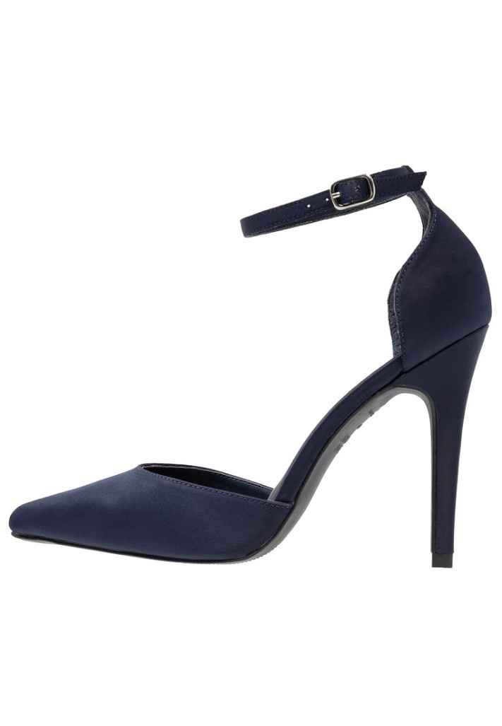 Zapato abierto lateralmente reduciendo el tacón a este y atadura en el tobillo