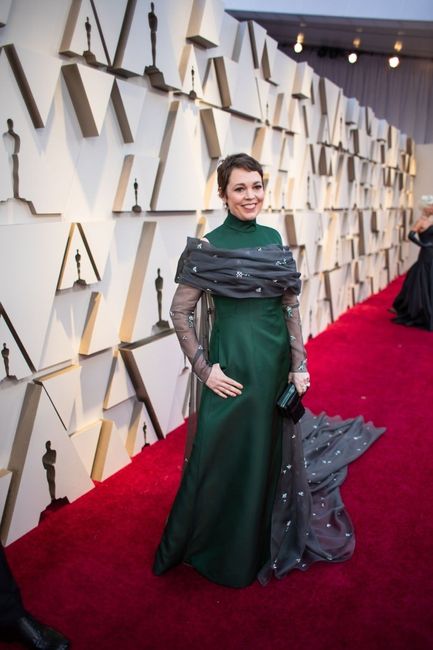 Olivia Colman con vestido verde con capa de Prada