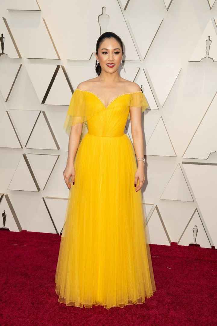 Constance Wu con vestido amarillo drapeado de Versace