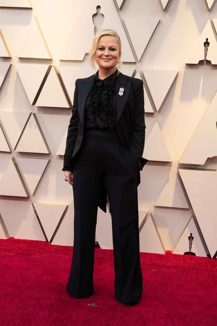 Amy Poehler con un look muy original de traje negro y camisa con chorreras a juego de Alberta Ferret