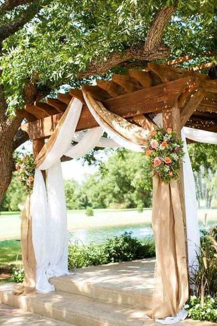 Pergola decorada con telas, flores y luces