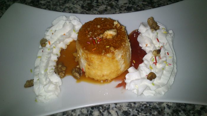 flan de queso fresco con culis de fresa, nata, virutas de chocolate y nueces
