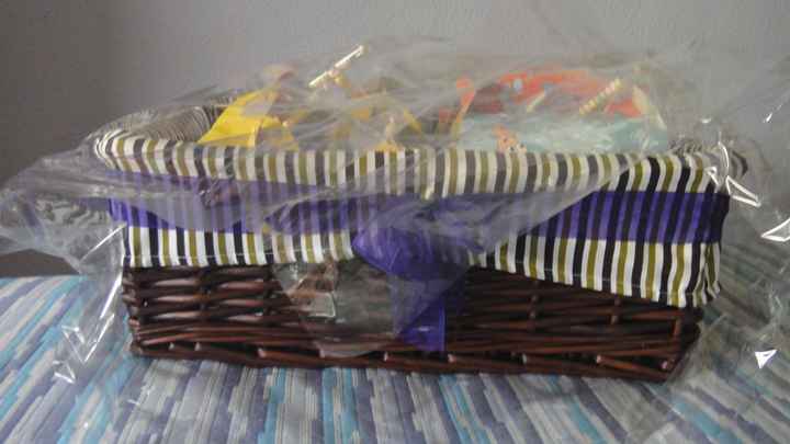 Cesta decorada con lazo de organza violeta con los regalos para los niños de la boda