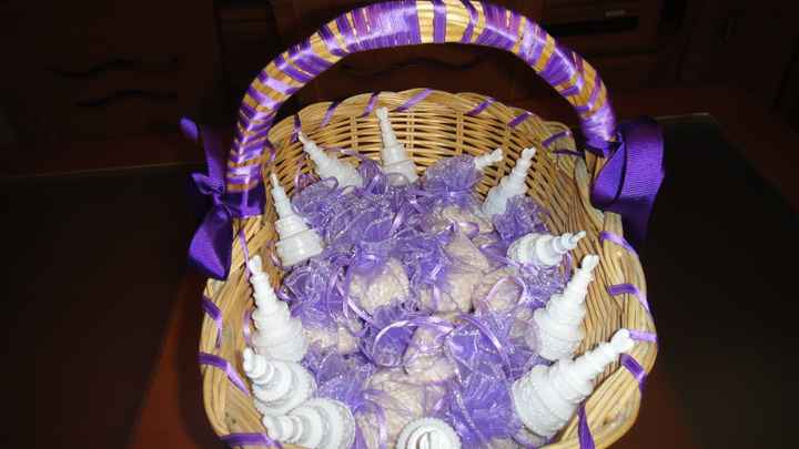 Cesta decorada con los paquetitos de arroz de organza lila y con los pomperos para los niños