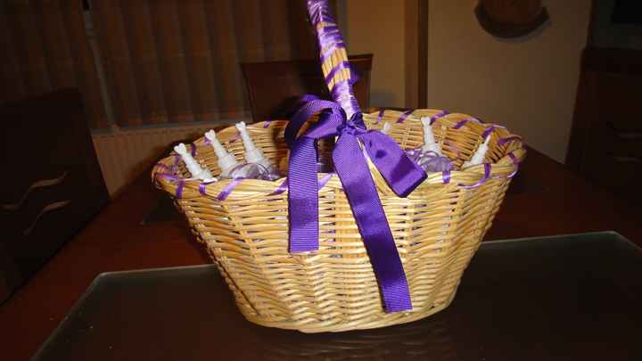 Cesta decorada con los paquetitos de arroz de organza lila y con los pomperos para los niños