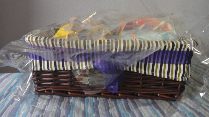 Cesta decorada con lazo de organza violeta con los regalos para los niños de la boda