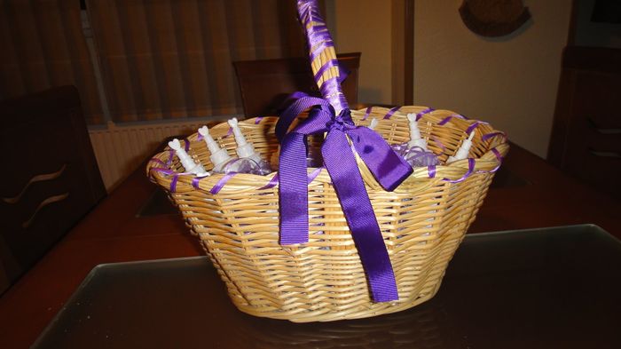 Cesta decorada con los paquetitos de arroz de organza lila y con los pomperos para los niños