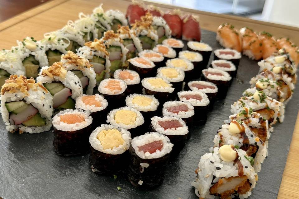 Nuestro combo de sushi variado, con uramakis de salmón y pepino, nigiri de atún y otras deliciosas combinaciones, servido en su caja de entrega: la forma perfecta de probar un poco de todo.