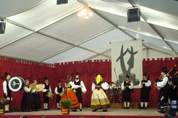 Banda de gaitas más dos parejas de baile en escenario