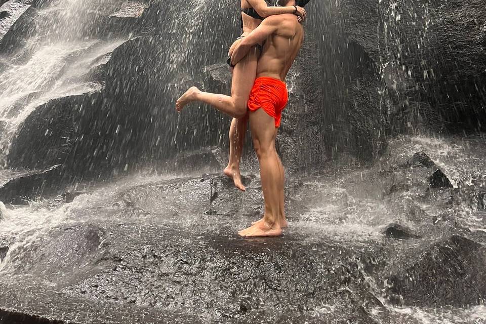 Novios Abrazados bajo Cascada Espectacular de Bali