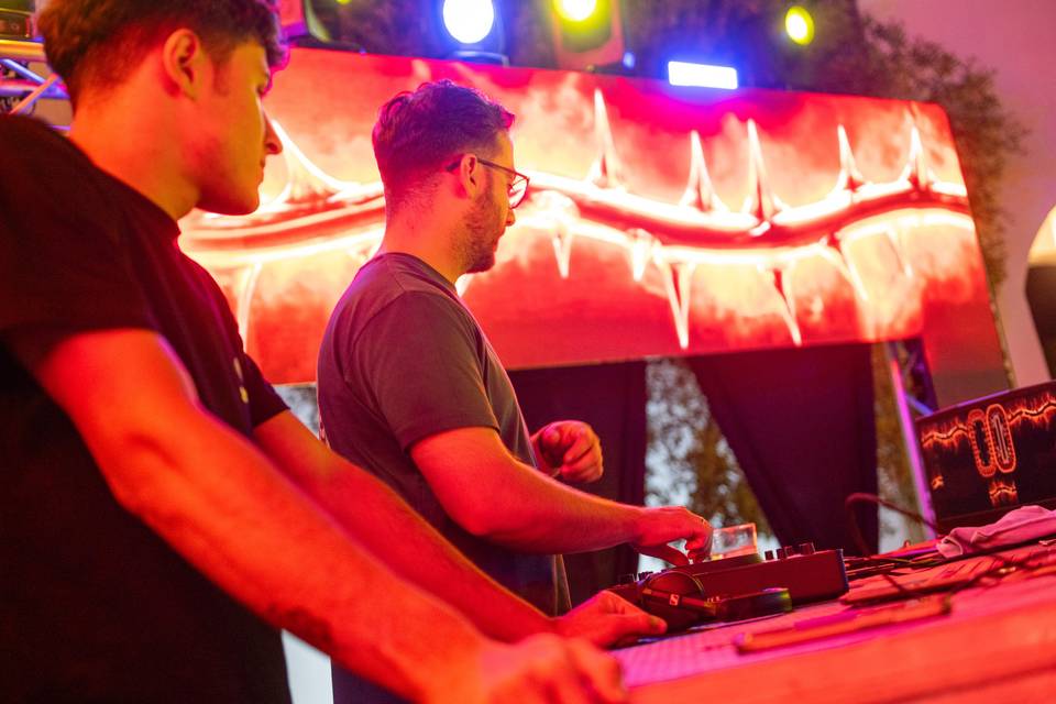 Primer plano de dj trabajando con luces rojas
