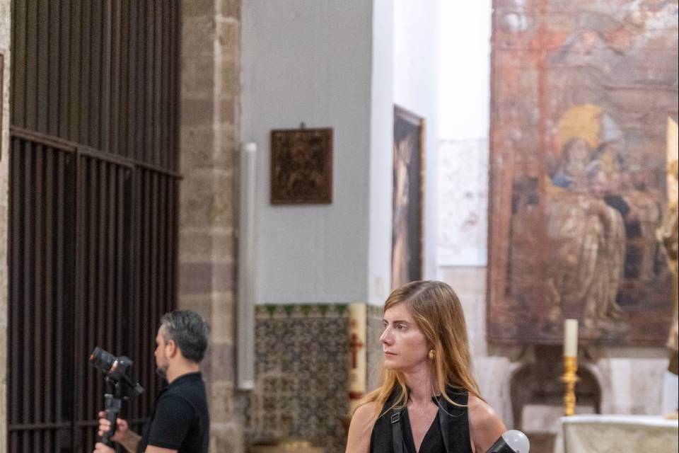 Fotógrafa de pie en el pasillo central de la iglesia