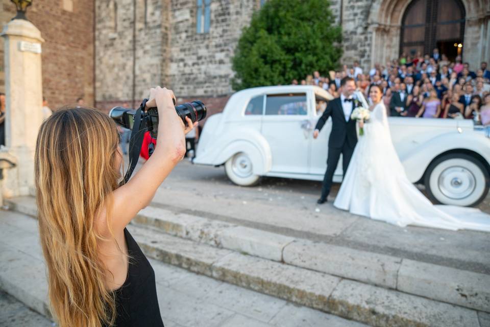 Fotógrafa grabando a la pareja junto al coche de bodas