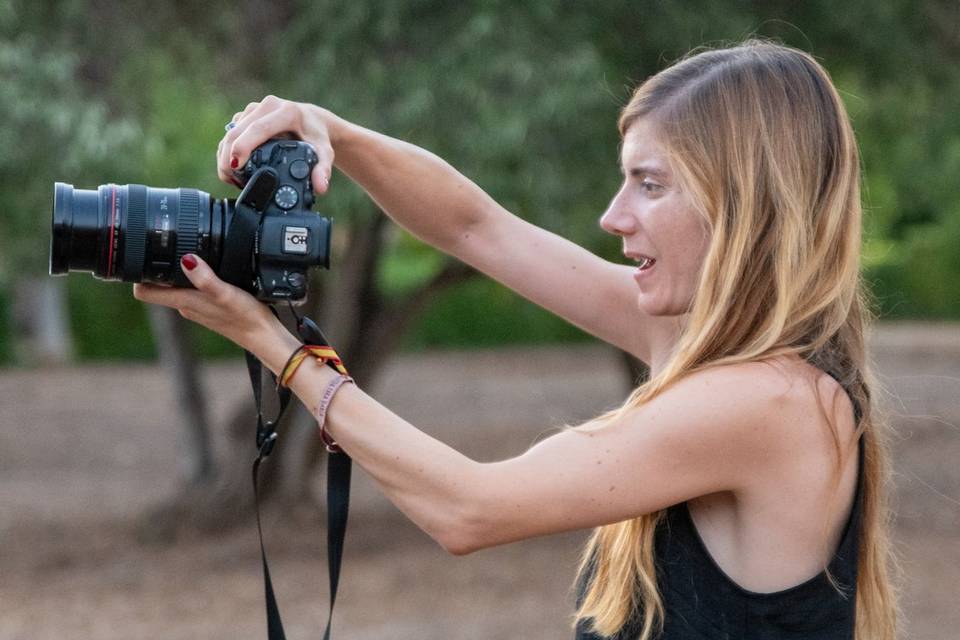 Fotógrafa preparada para disparar en un jardín al atardecer
