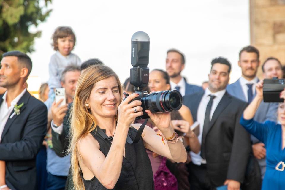 Fotógrafa sosteniendo la cámara en alto sobre los invitados
