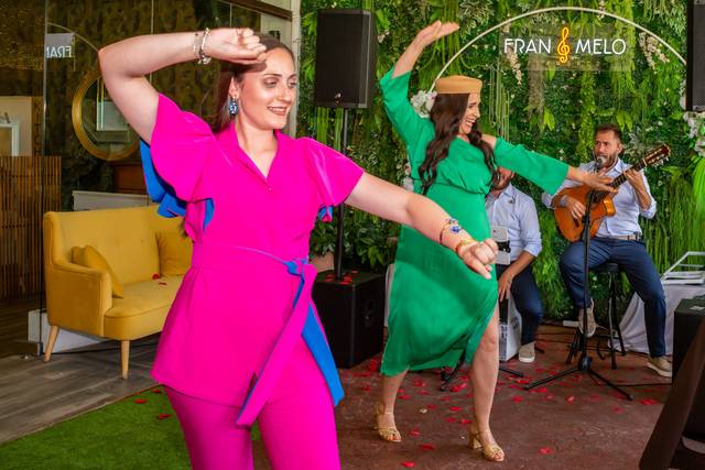 Dos mujeres con vestidos brillantes bailando