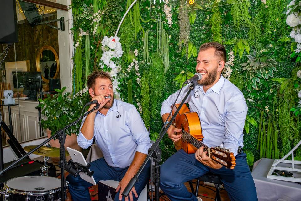 Dos músicos sentados tocando guitarras
