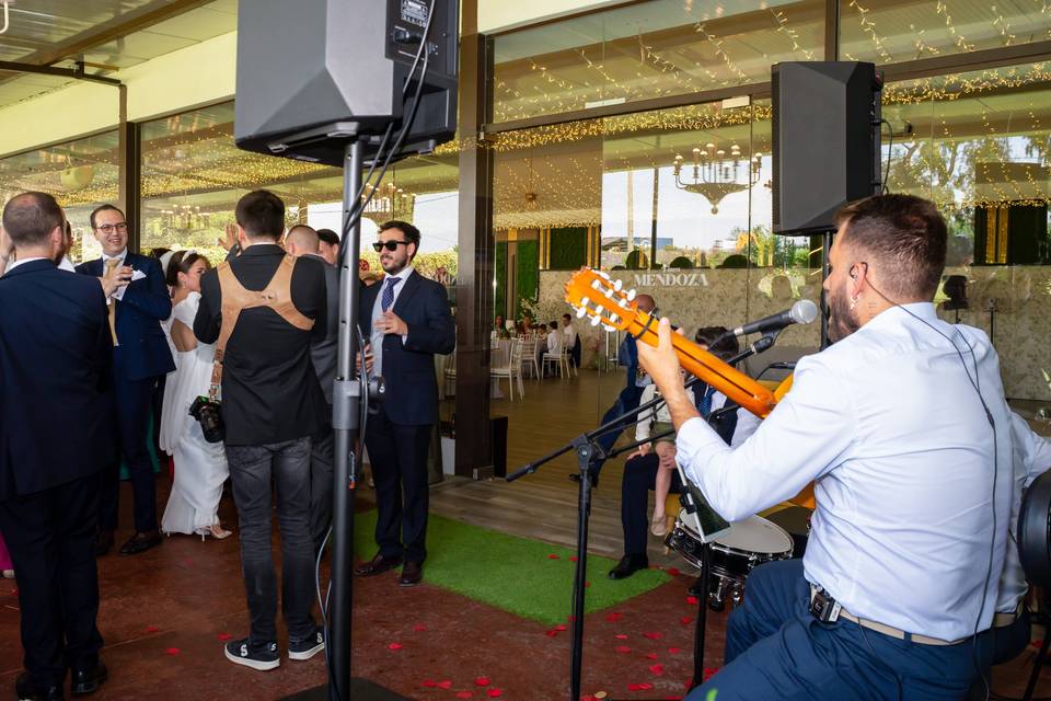 Músicos tocando con invitados de fondo