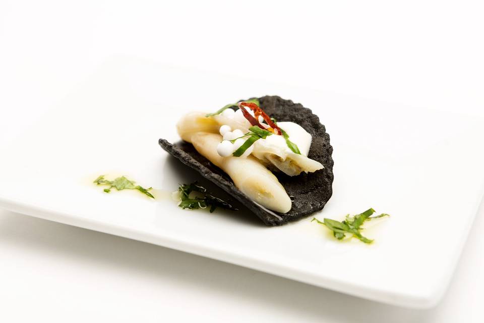 Tostita de ajo negro y tinta de calamar, con navaja, perlas de coco, cilantro y chile