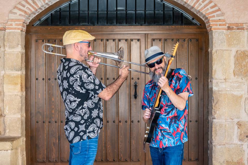 Trombonista y guitarrista bajo un arco