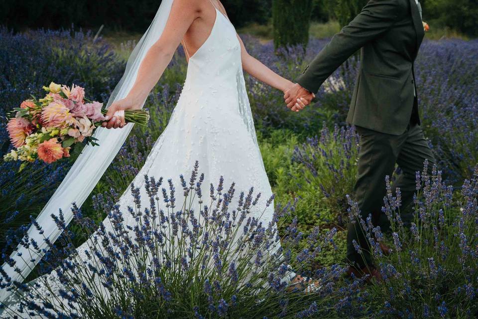 Novios corriendo por un campo de lavanda